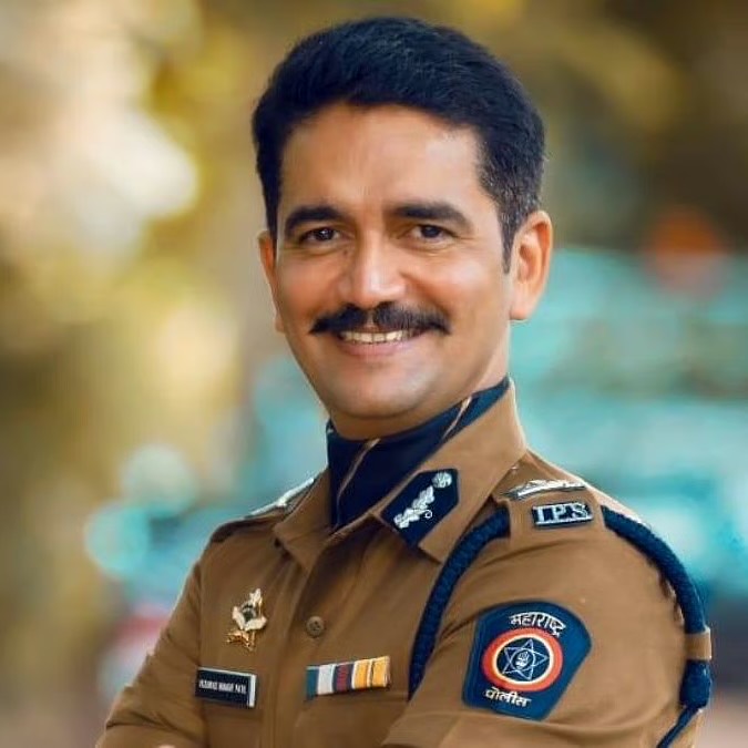 Portrait of Vishwas Nangre Patil in Indian Police Service uniform, arms folded, smiling