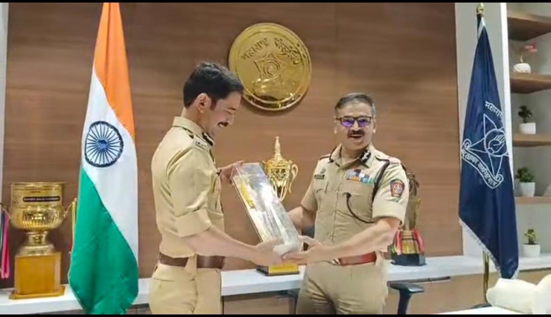 Vishwas Nangre Patil in uniform being presented with a memento by a senior police officer