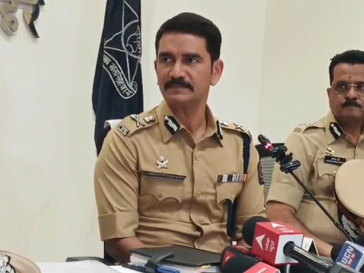 Vishwas Nangre Patil in uniform at a press briefing with microphones on the table in front of him