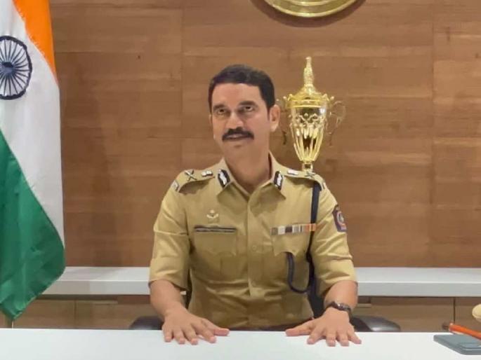 Vishwas Nangre Patil seated at his office desk in uniform beside a trophy and the national flag