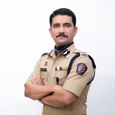 Formal studio portrait of Vishwas Nangre Patil in Indian Police Service uniform with arms folded